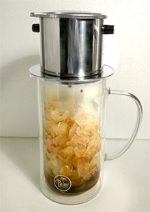 Phin filter brewing iced coffee in a pitcher